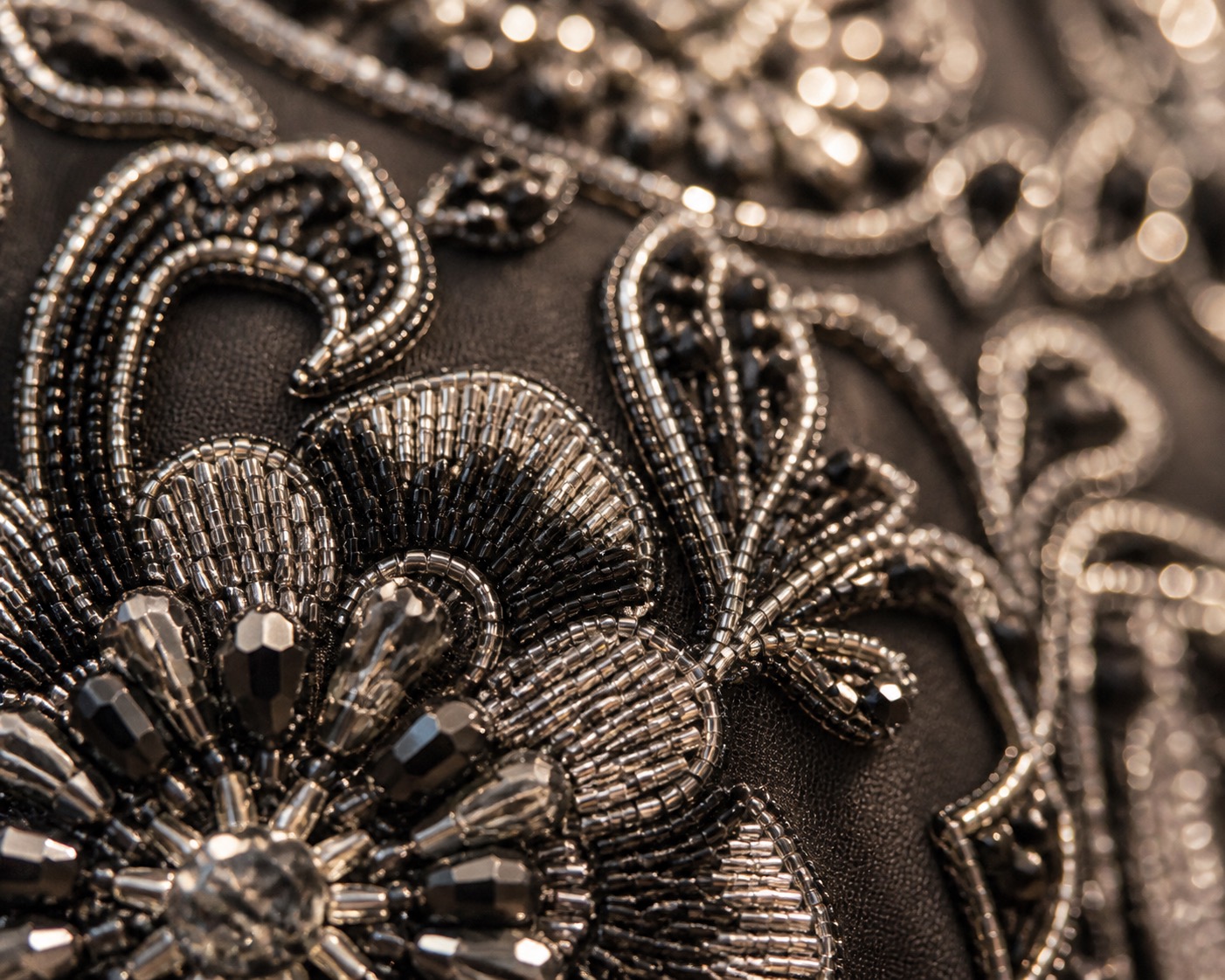 Macro detail of hand-applied beadwork on a cape